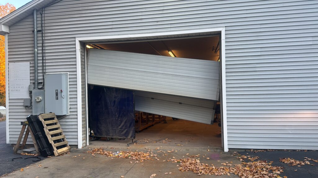 Technician repairing a commercial overhead door at a loading bay to restore safe access.